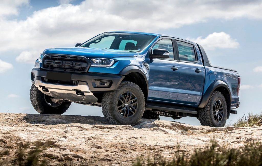 A blue 2021 Ford Ranger Raptor traversing a rocky terrain.