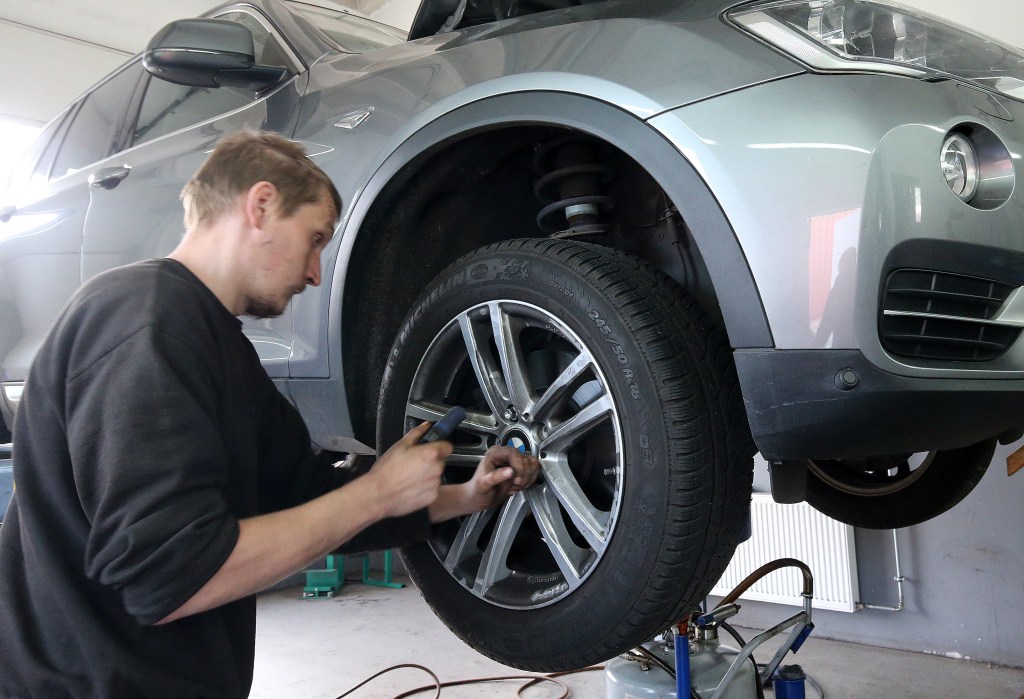 A mechanic at the Krause car service workshop in the Lichtenberg district changes the tires on a vehicle from summer to winter tires