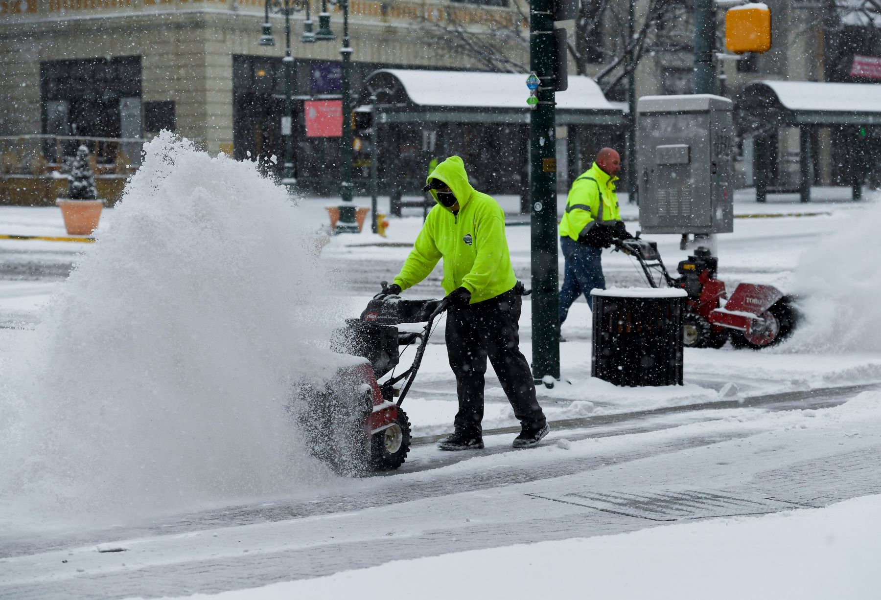 A pair of Public Works city workers clearing snow on a street using snow blowers in Reading, Pennsylvania