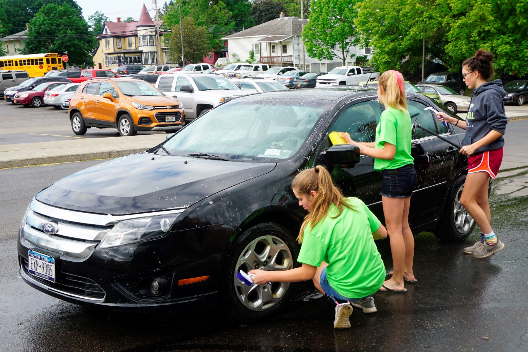 Middle school students washing cars for community service in Wellsville, New York