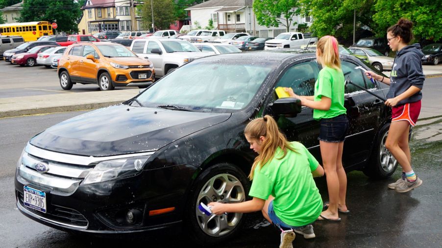 Middle school students washing cars for community service in Wellsville, New York