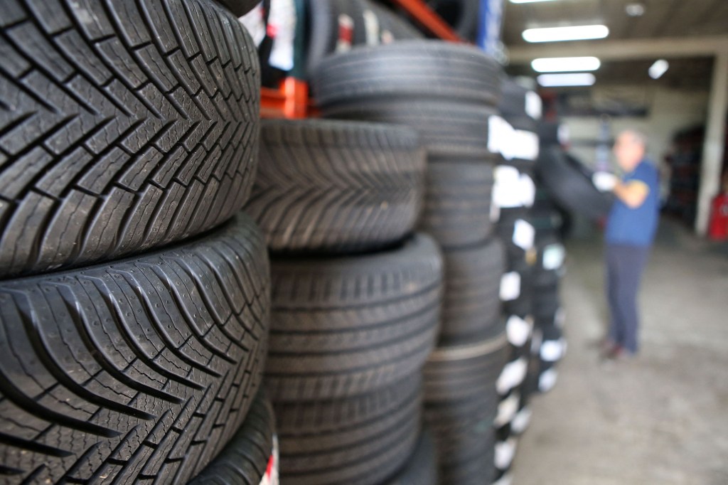 A mechanic removes winter tires from storage to be put on a vehicle, at a garage in Ajaccio, on the French Mediterranean island of Corsica