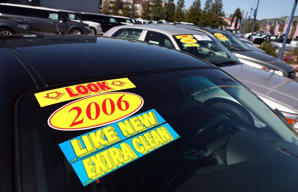 A sale sign is seen on the windshield of a used car at Novato Ford in Novato, California.