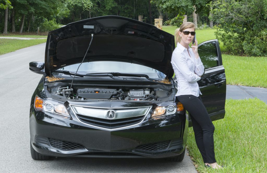 Young woman with the car broken down on side of the road.