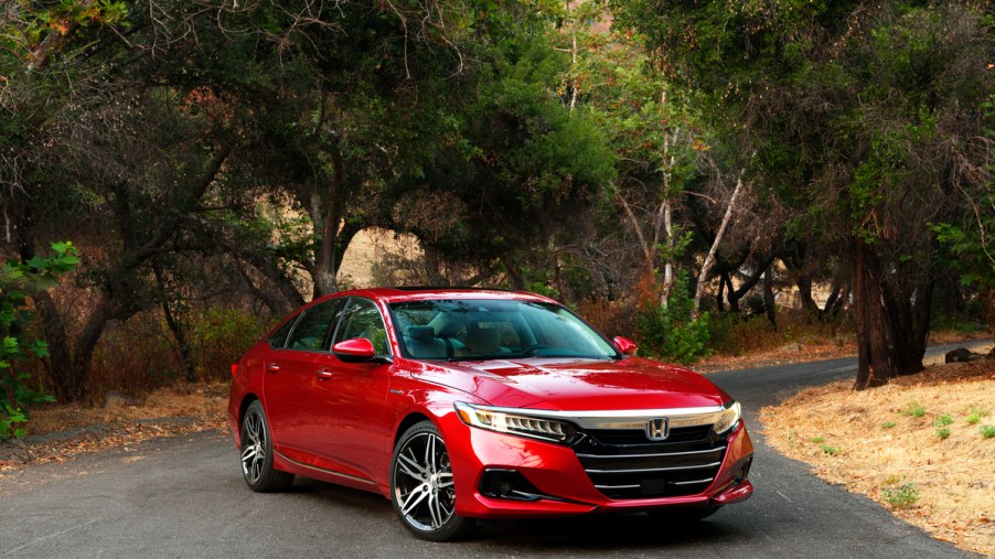 A 3/4 front view of a red 2021 Honda Accord Hybrid sedan.