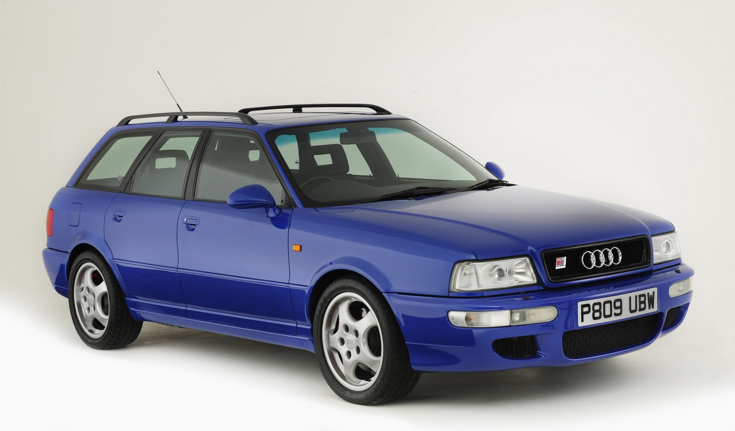 A Nogaro Blue 1995 Audi RS2 Avant, a Euro-only wagon, shot from the front 3/4 in a photo studio
