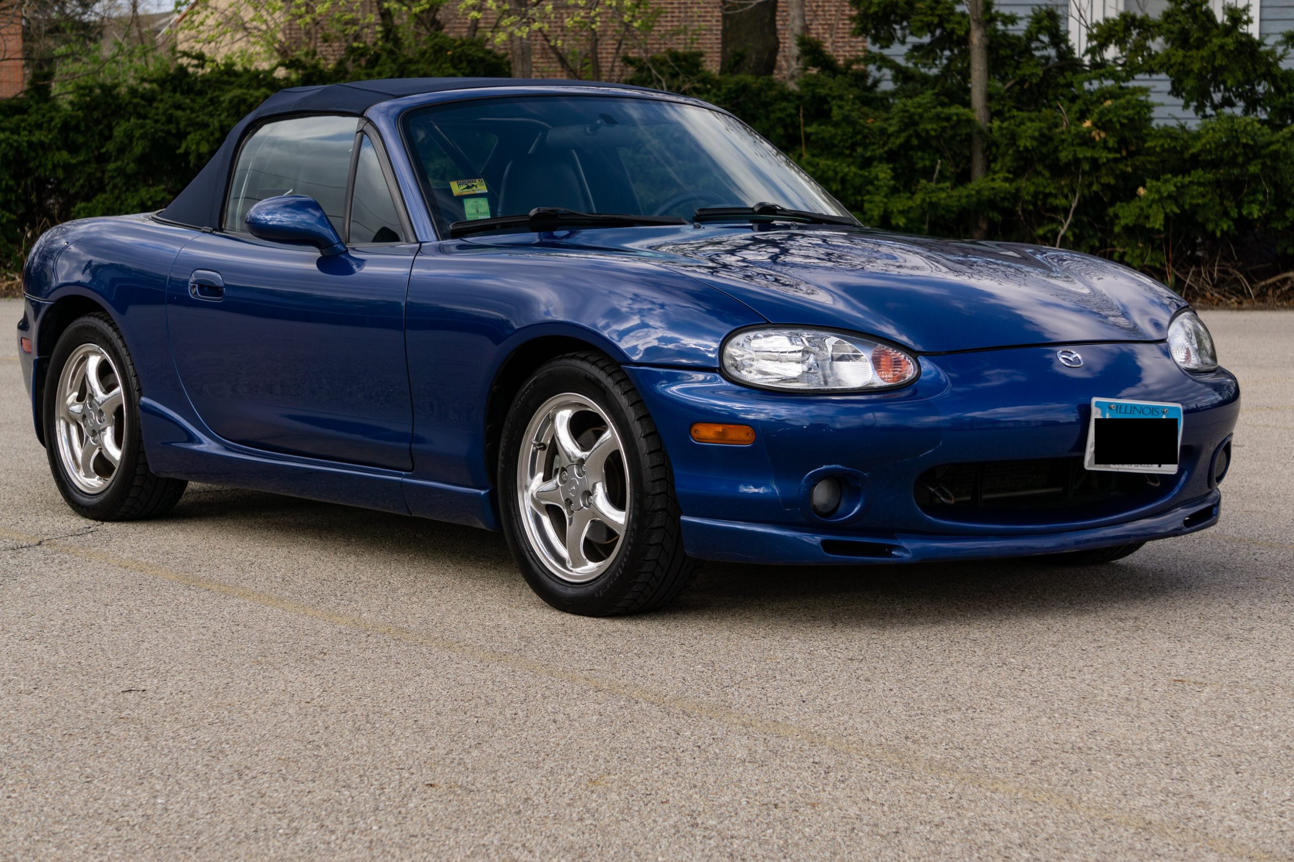 A blue 1999 NB Mazda MX-5 Miata 10th Anniversary Edition in a parking lot