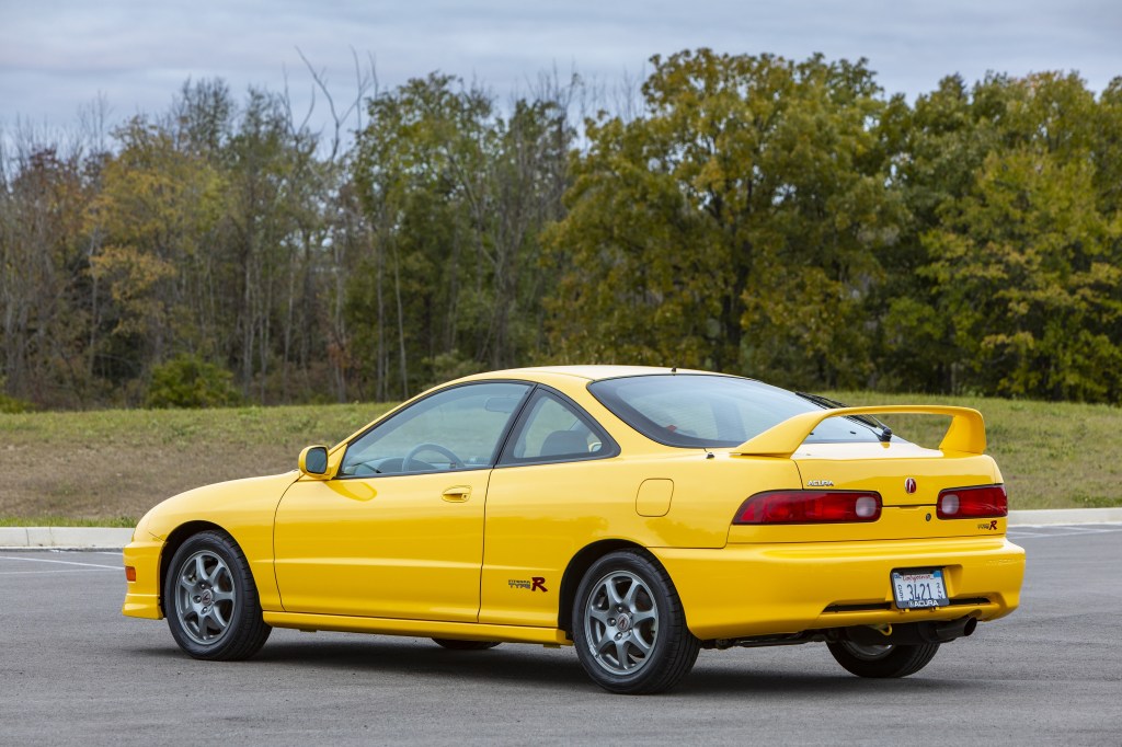 The rear 3/4 view of a yellow 2000 Acura Integra Type R