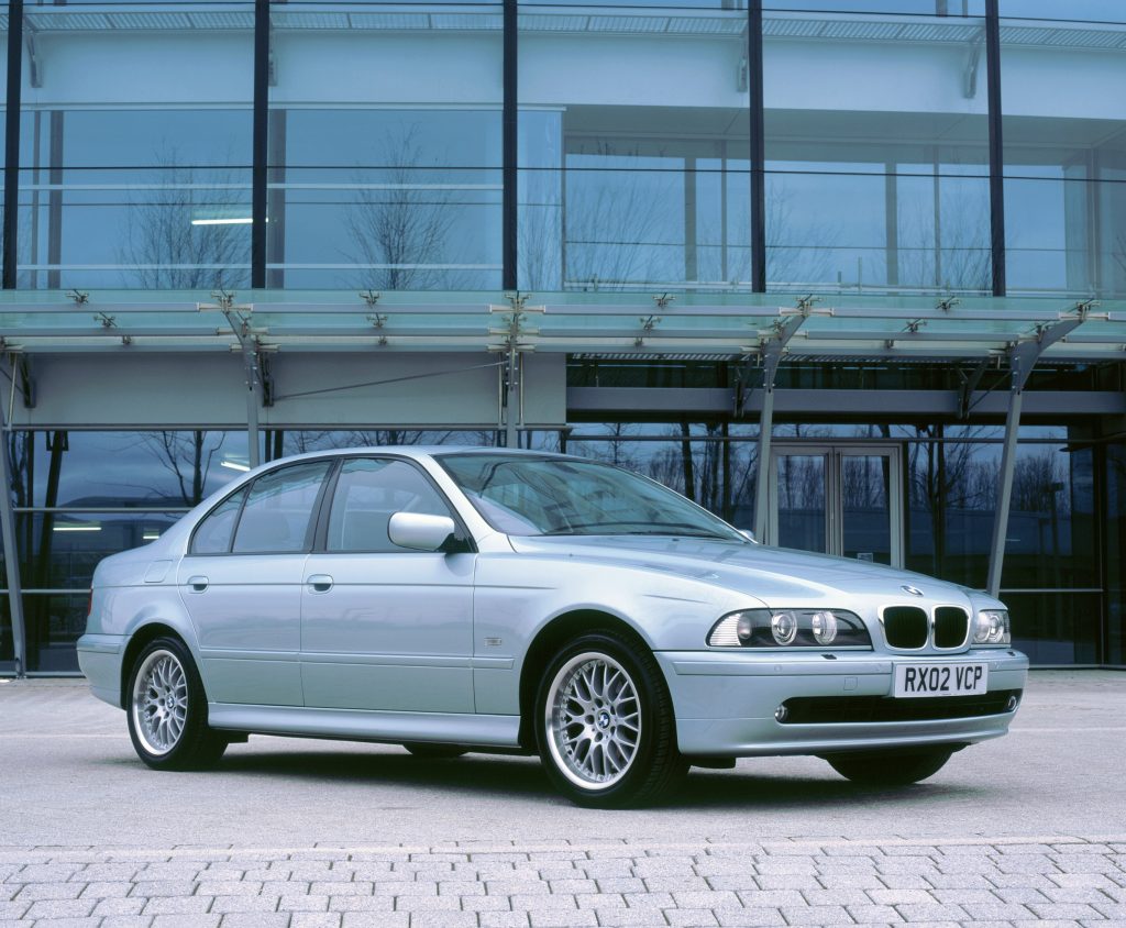 A silver 2002 BMW 530i in front of an office building
