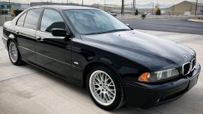 A black 2003 E39 BMW 530i with Sport Package on a parking garage roof