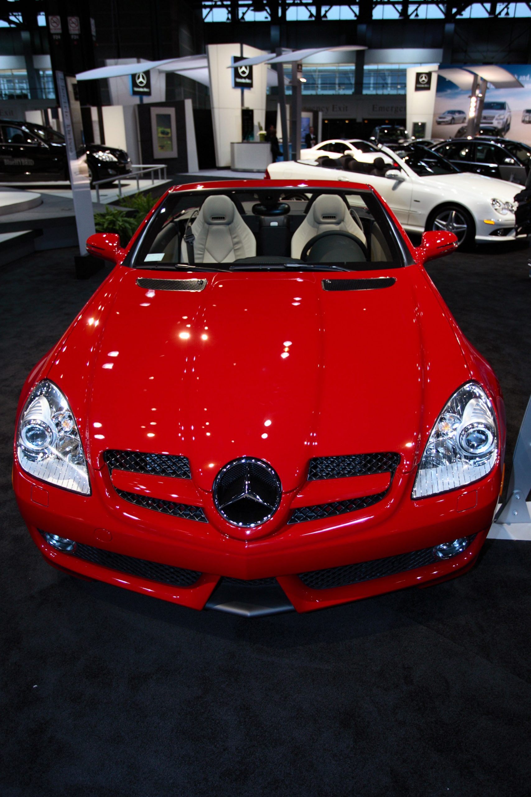The front view of a red 2009 Mercedes SLK 55 AMG at a car show