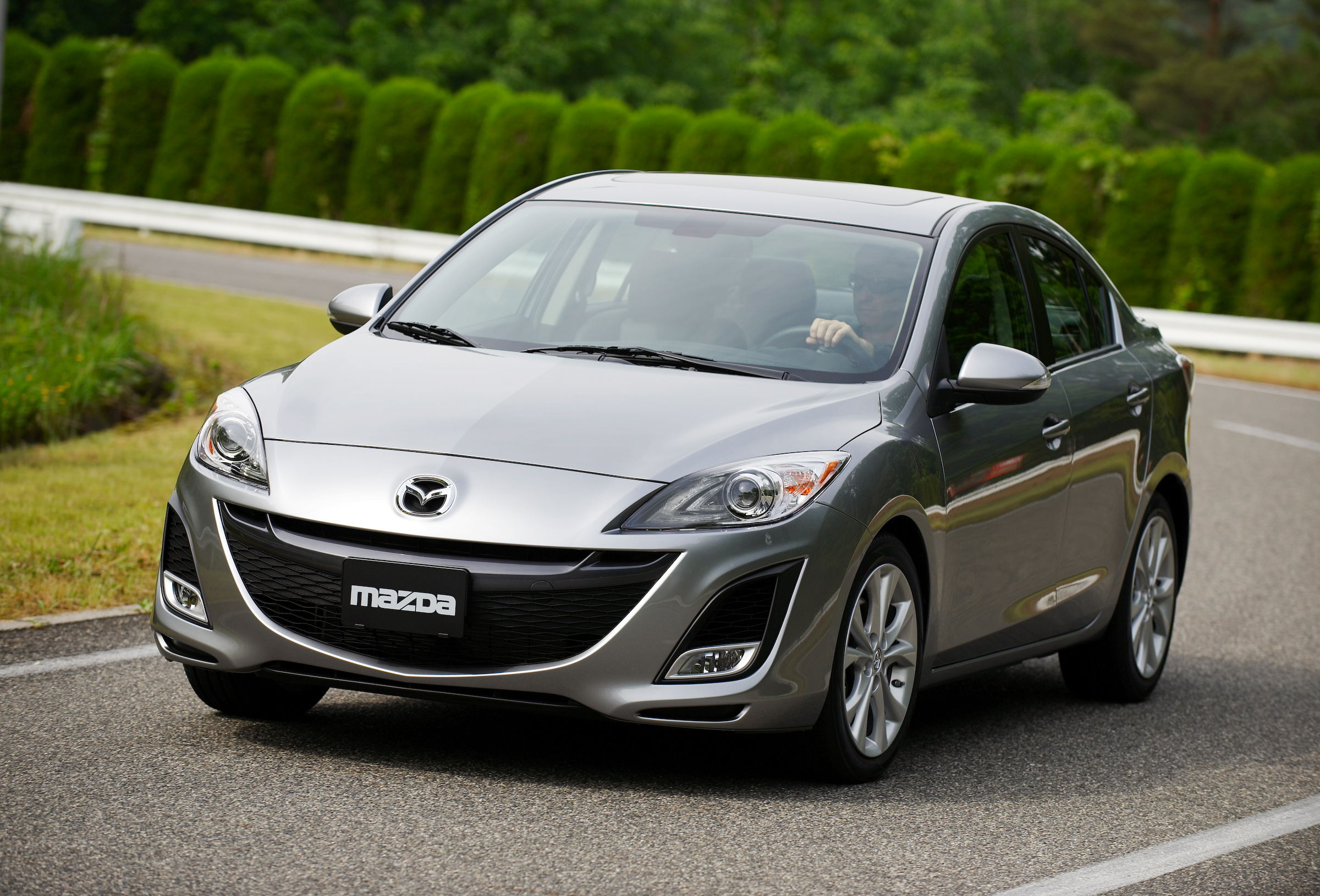 A silver Mazda3 subcompact car shot from the front 3/4