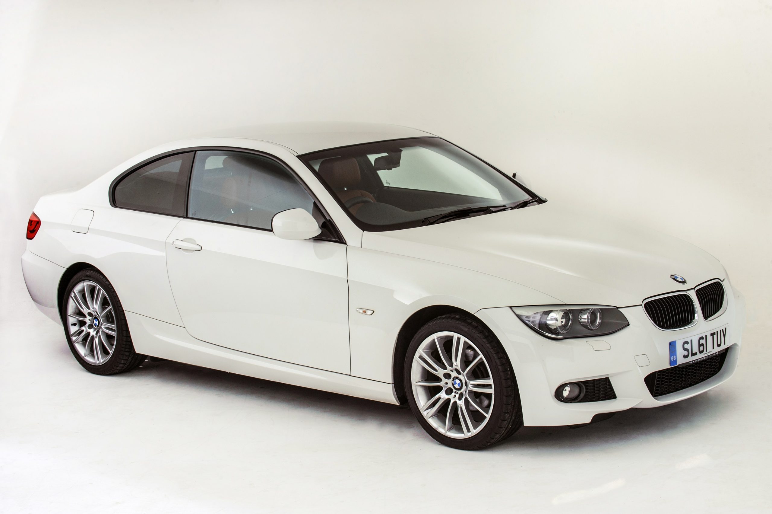 A white 2011 BMW 3 Series coupe shot from the front 3/4