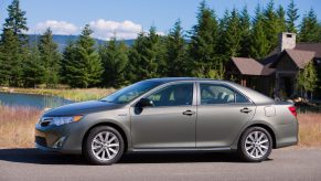 A profile view of a brown 2012 Toyota Camry Hybrid Sedan.