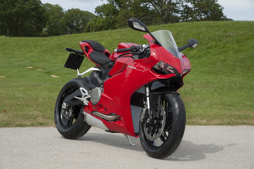 A red 2014 Ducati 899 Panigale parked by a lawn