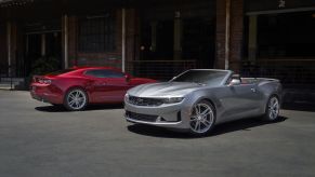 2021 Chevrolet Camaro LS and LT models in red and silver parked outside of a brick building
