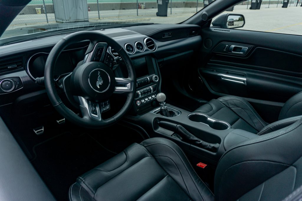 The black cloth-and-leather front seats and black dashboard of a 2021 Ford Mustang Mach 1 with the Handling Package