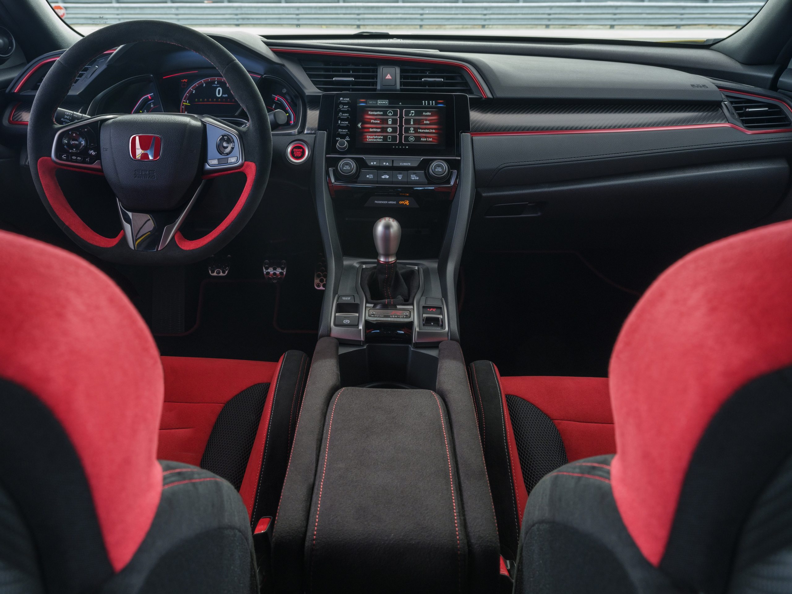 The interior of the Honda Civic Type R with red seats and a manual transmission