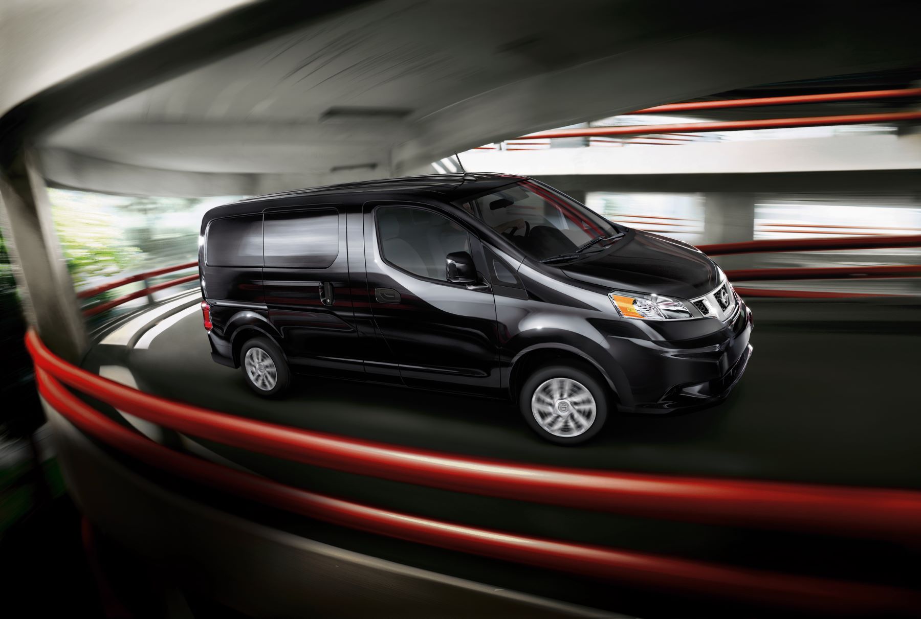 A promotional shot of a 2021 Nissan NV200 light commercial van driving through a parking garage