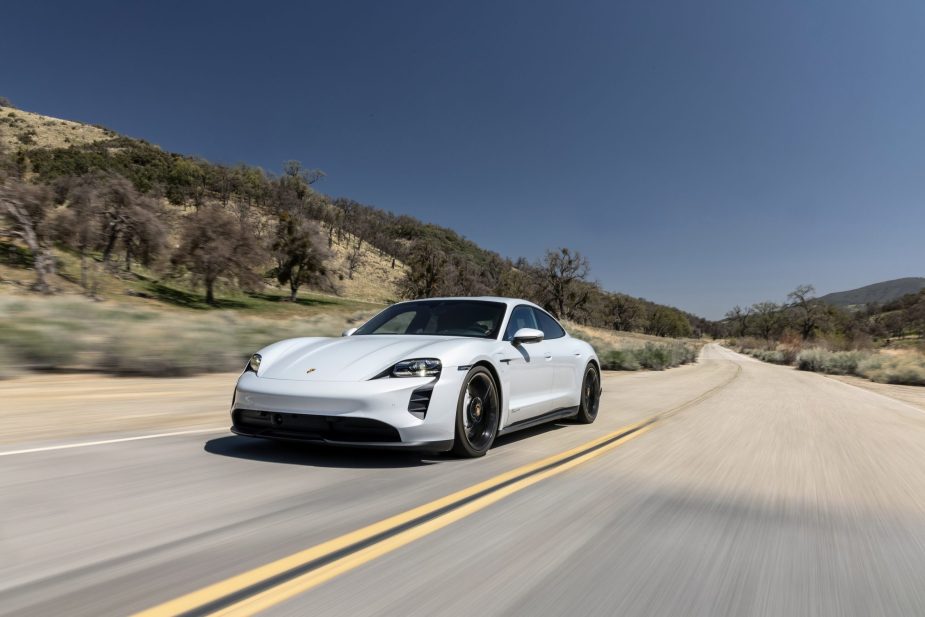 A white 2021 Porsche Taycan drives down a desert road