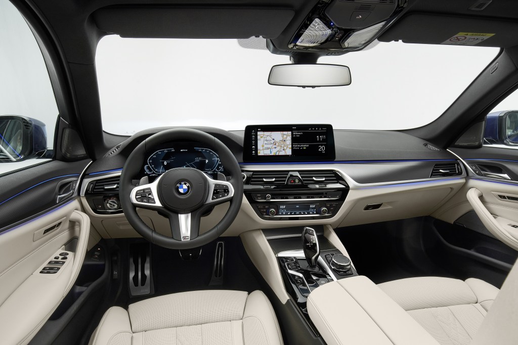 The white-leather front seats and black dashboard of a 2022 BMW 5 Series