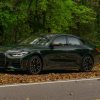 The front 3/4 view of a green 2022 BMW M440i xDrive Gran Coupe in a forest