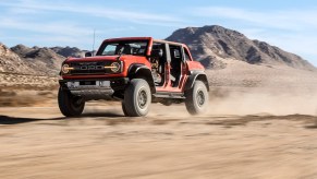 Orange 4x4 SUV speeding across the desert