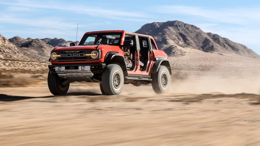 Orange 4x4 SUV speeding across the desert