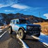 A blue 2022 Ford Bronco shot from the front 3/4 at Colorado's Red Rocks