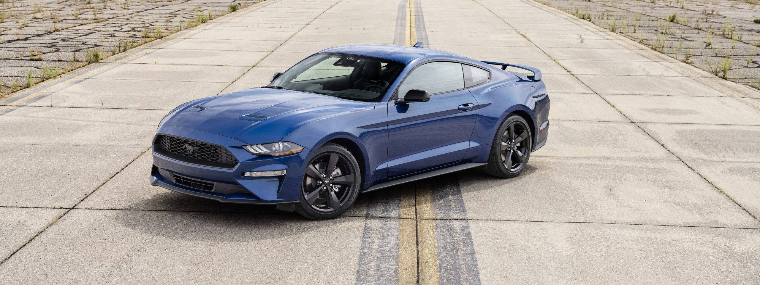 A blue 2022 Ford Mustang Stealth Edition shot from the front 3/4 on a runway