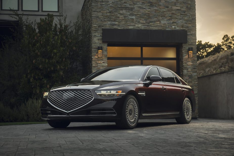 A maroon 2022 Genesis G90 in front of a house