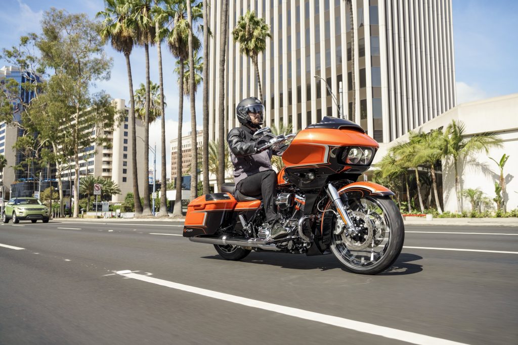 A rider on an orange-and-black 2022 Harley-Davidson CVO Road Glide