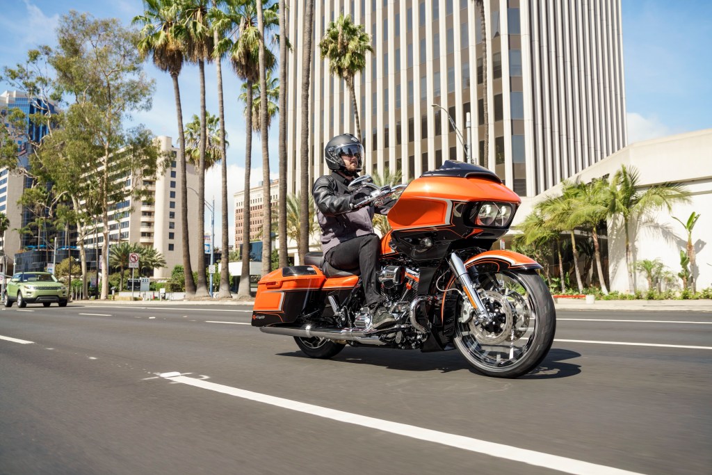A rider on an orange-and-black 2022 Harley-Davidson CVO Road Glide