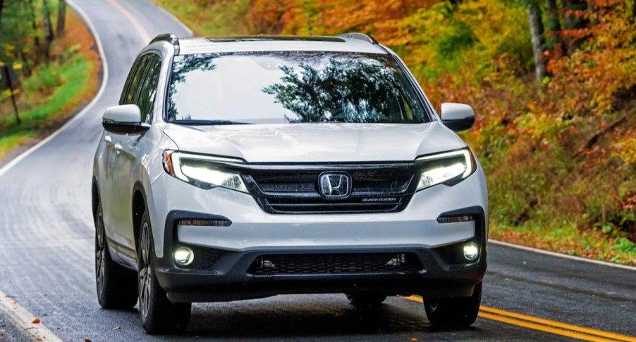A gray 2022 Honda Pilot is driving on the road.