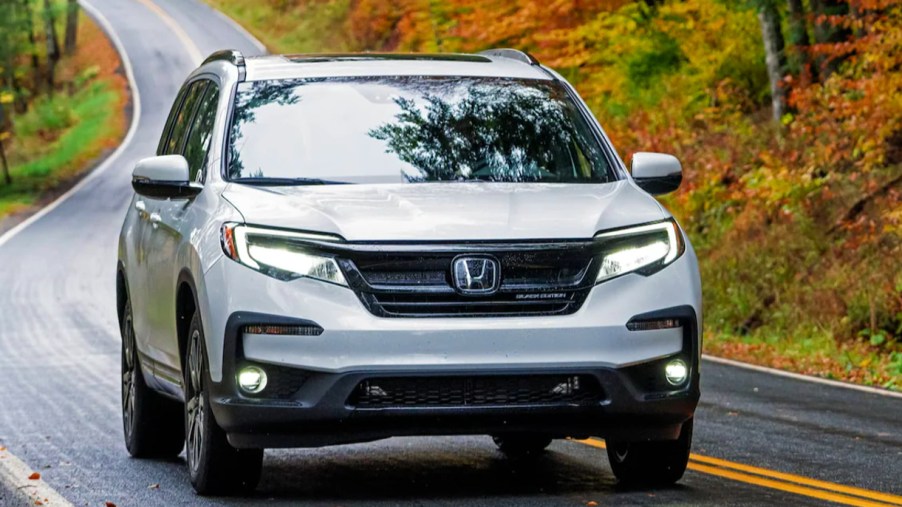 A gray 2022 Honda Pilot is driving on the road.