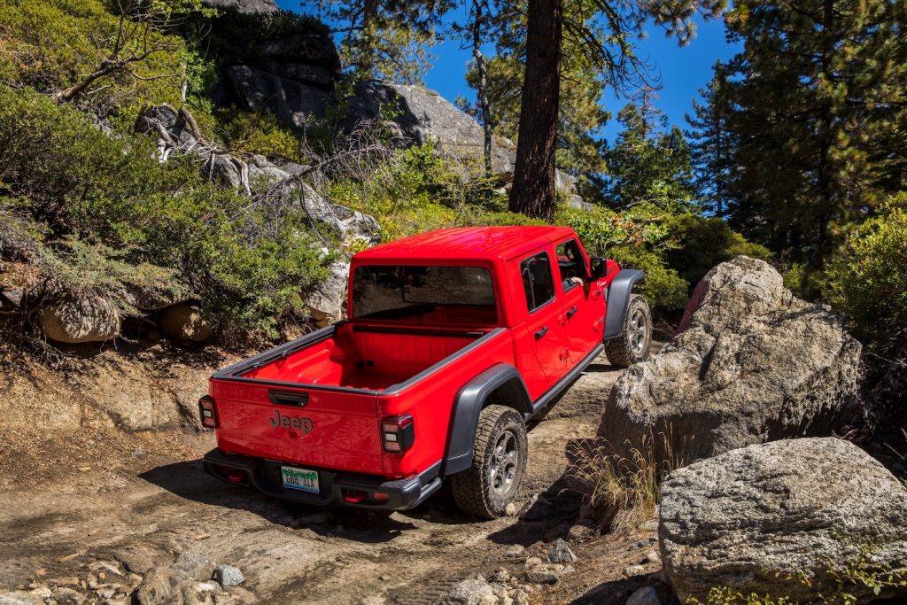 This is a promo photo of a red Jeep Gladiator Rubicon on a trail.