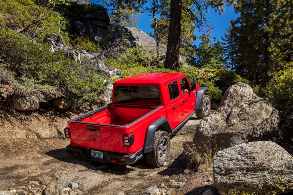 This is a promo photo of a red Jeep Gladiator Rubicon on a trail.