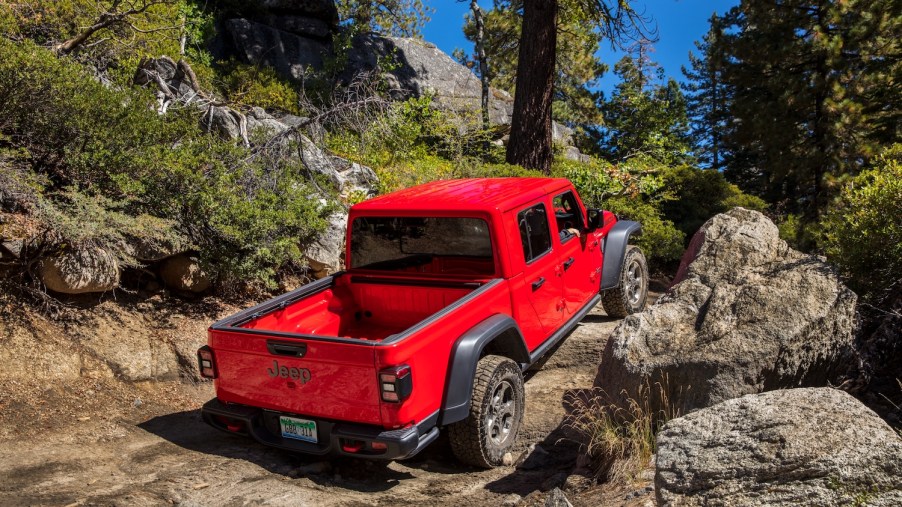 This is a promo photo of a red Jeep Gladiator Rubicon on a trail.