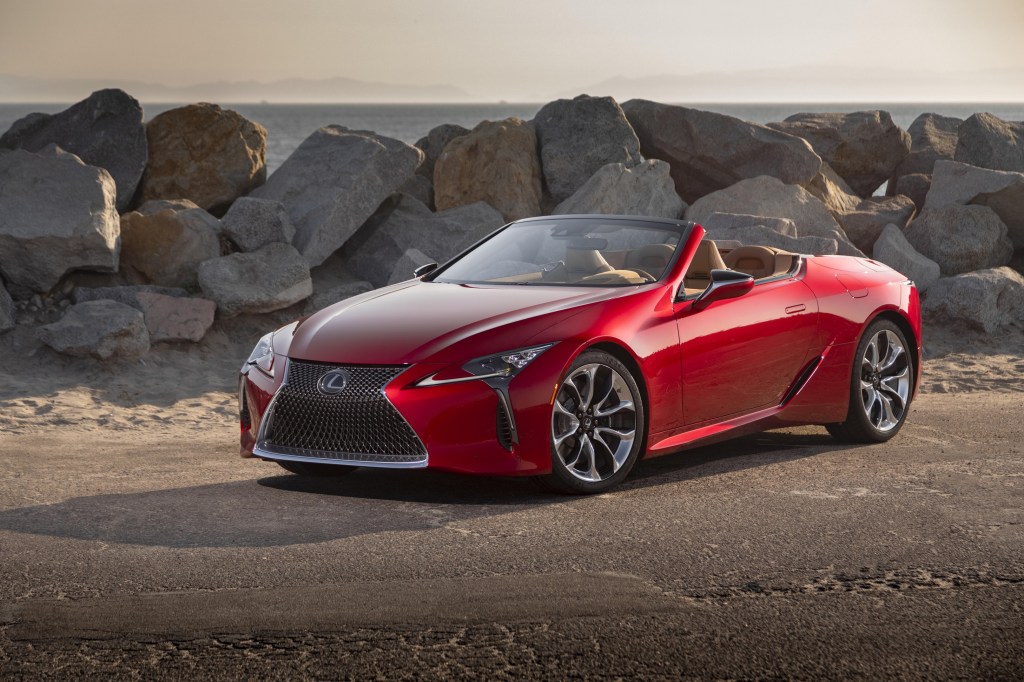 A red 2022 Lexus LC 500 Convertible parked by some rocks by a beach