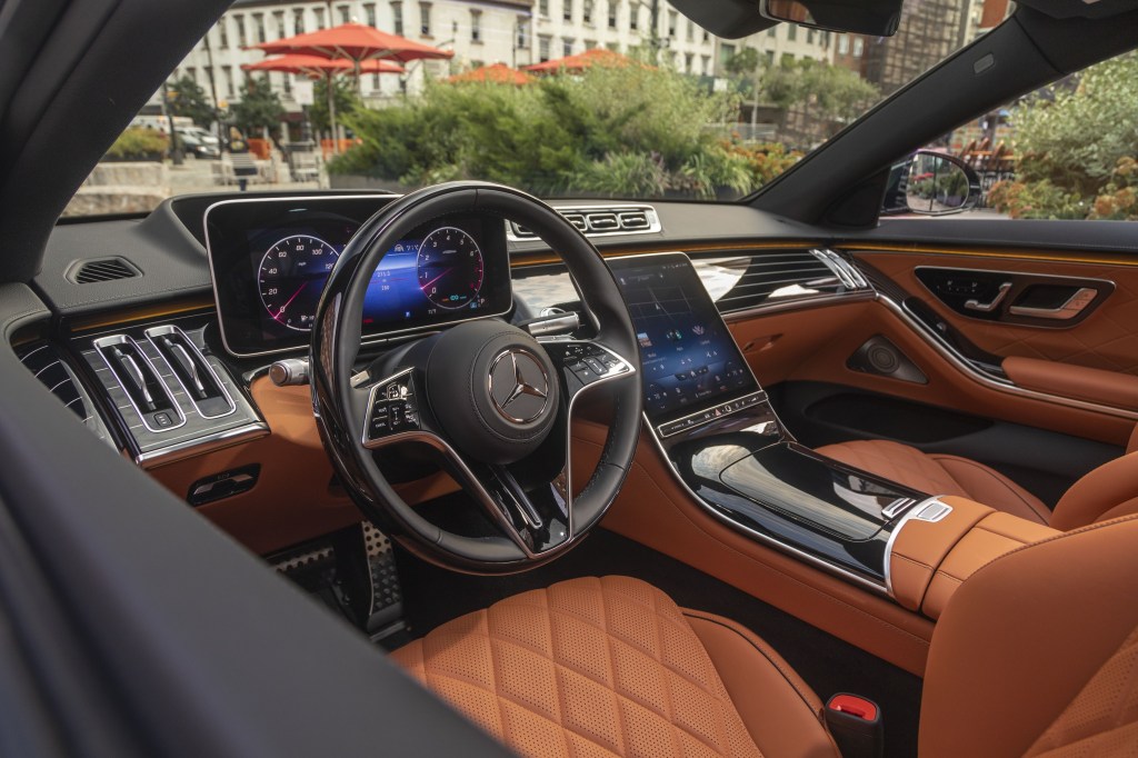 The brown-leather-upholstered front seats and black dashboard of a 2022 Mercedes S 500 4Matic S-Class Sedan