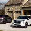 2022 Mitsubishi Outlander SUVs parked in a large rustic home's driveway