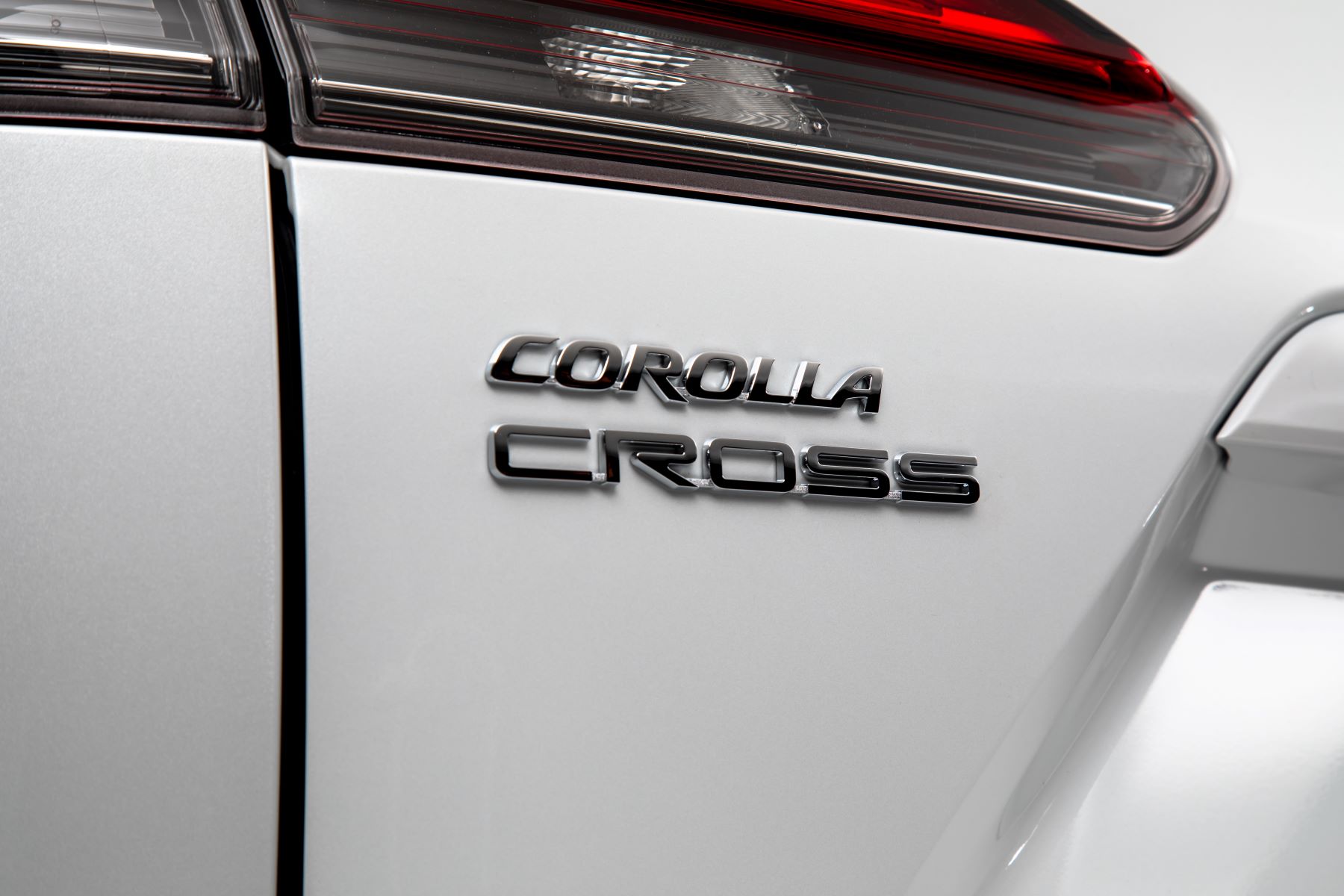 The 2022 Toyota Corolla Cross compact crossover SUV with Wind Chill Pearl paint color option and showing its model badging