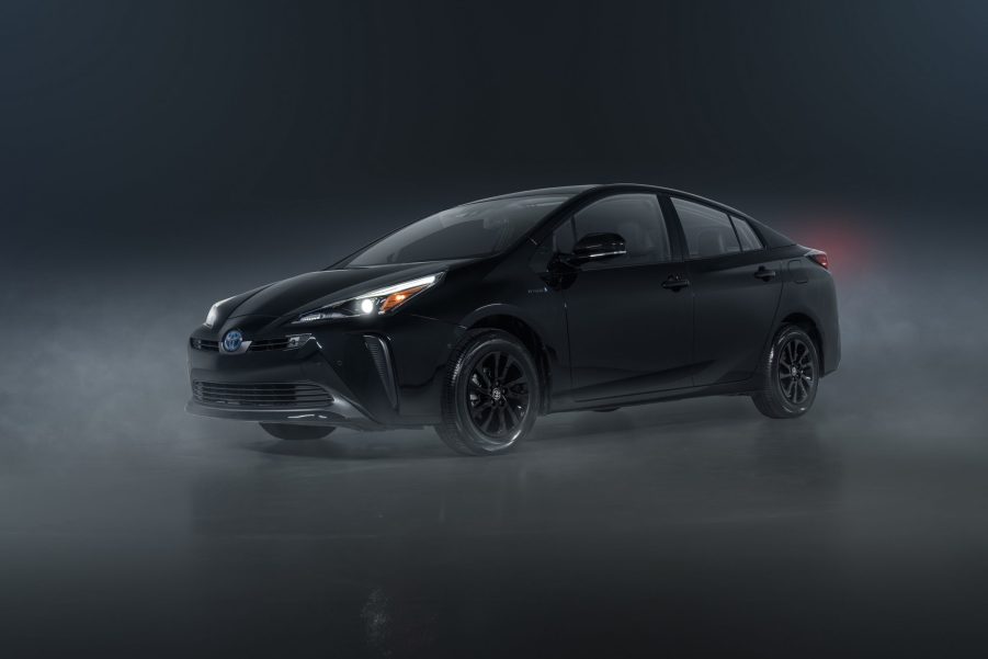 A black 2022 Toyota Prius with AWD shot from the front 3/4 in a dark photo studio