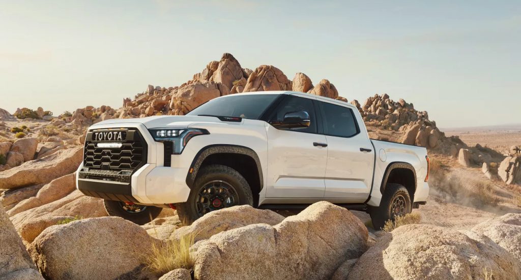 A white 2022 Toyota Tundra is driving on rocks. 