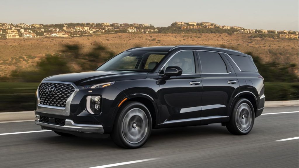 A black 2022 Hyundai Palisade driving down a road.
