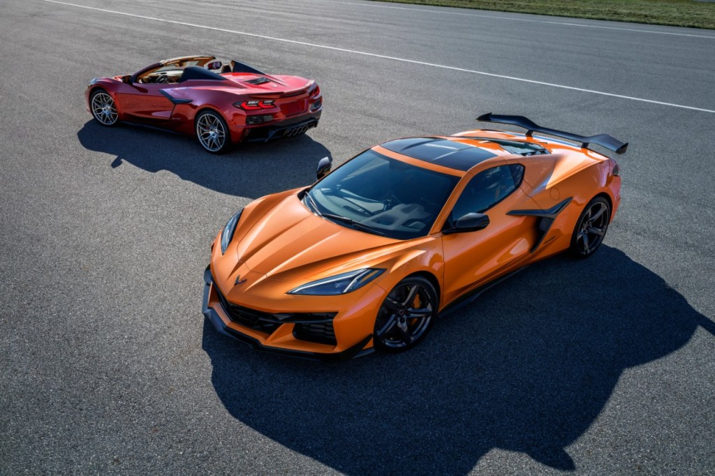 A bright orange Corvette C8 Z06 sits in front of a red C8 Corvette convertible.