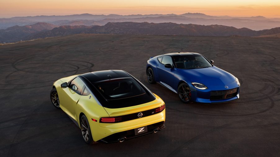 A pair of 2023 Nissan Z cars in yellow and blue shot on the a cliffside at sunset