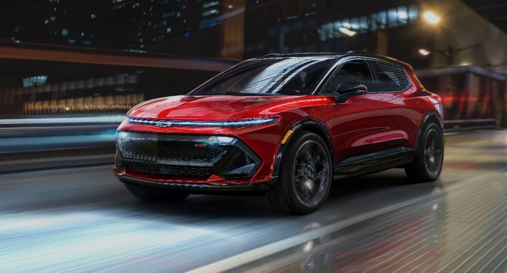 A red 2024 Chevy Equinox electric SUV is driving on the road.