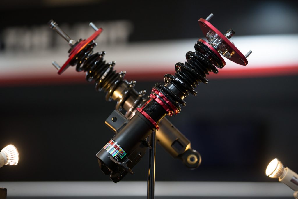 A set of black-red-and-gold Blitz coilovers at the 2017 Tokyo Auto Salon