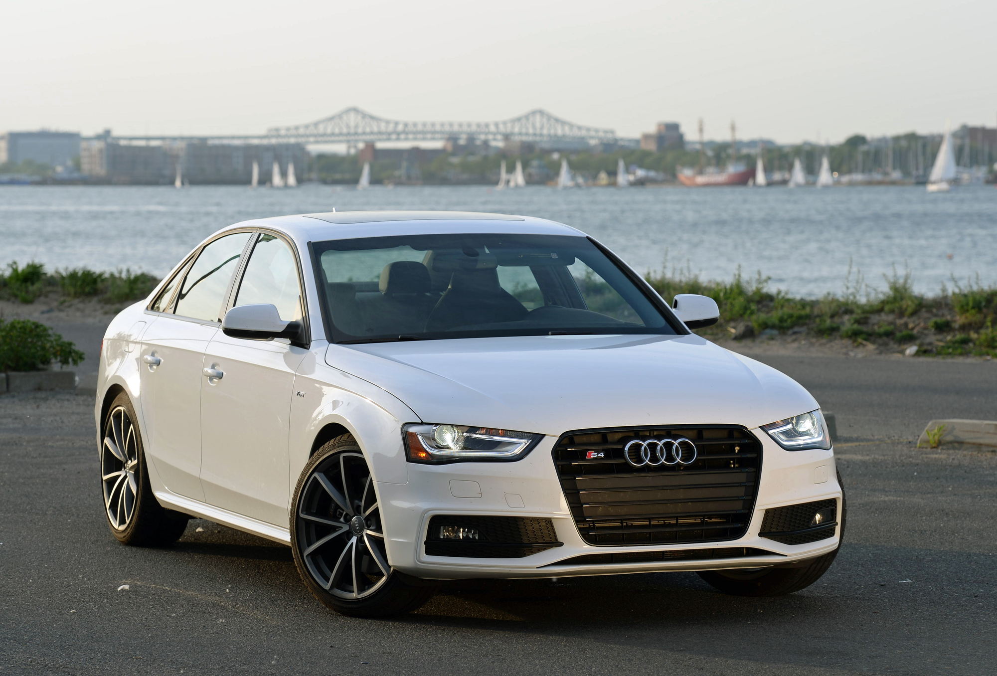 A white Audi S4 sedan shot from the front 3/4 at sunset